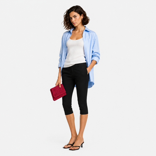 Model holding THE CLUTCH BAG in cherry red, styled with light blue shirt and black cropped trousers