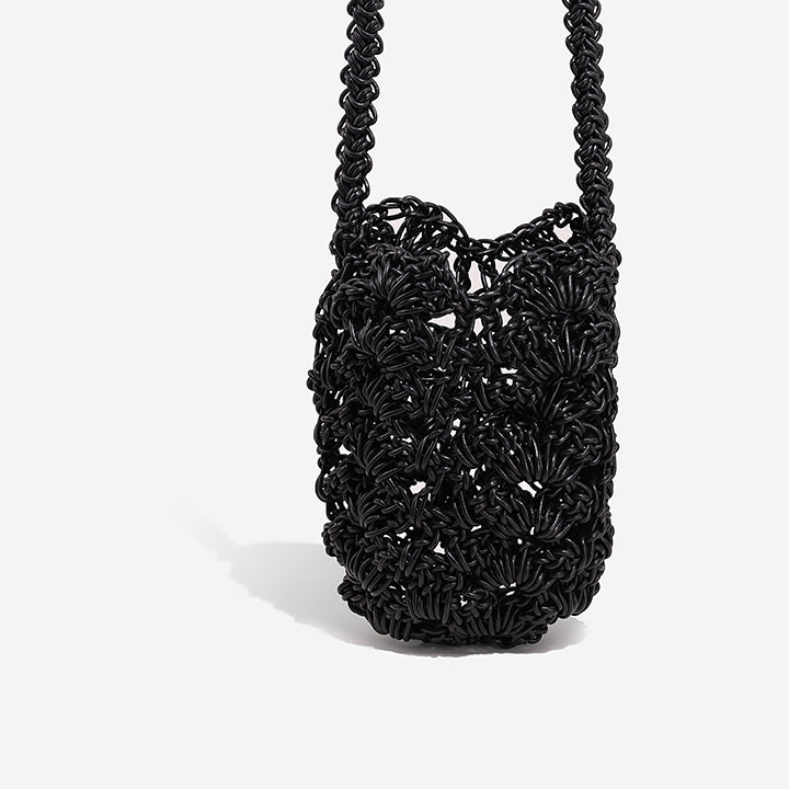 THE LACE BAG in black — side view of openwork crochet leather mini bag