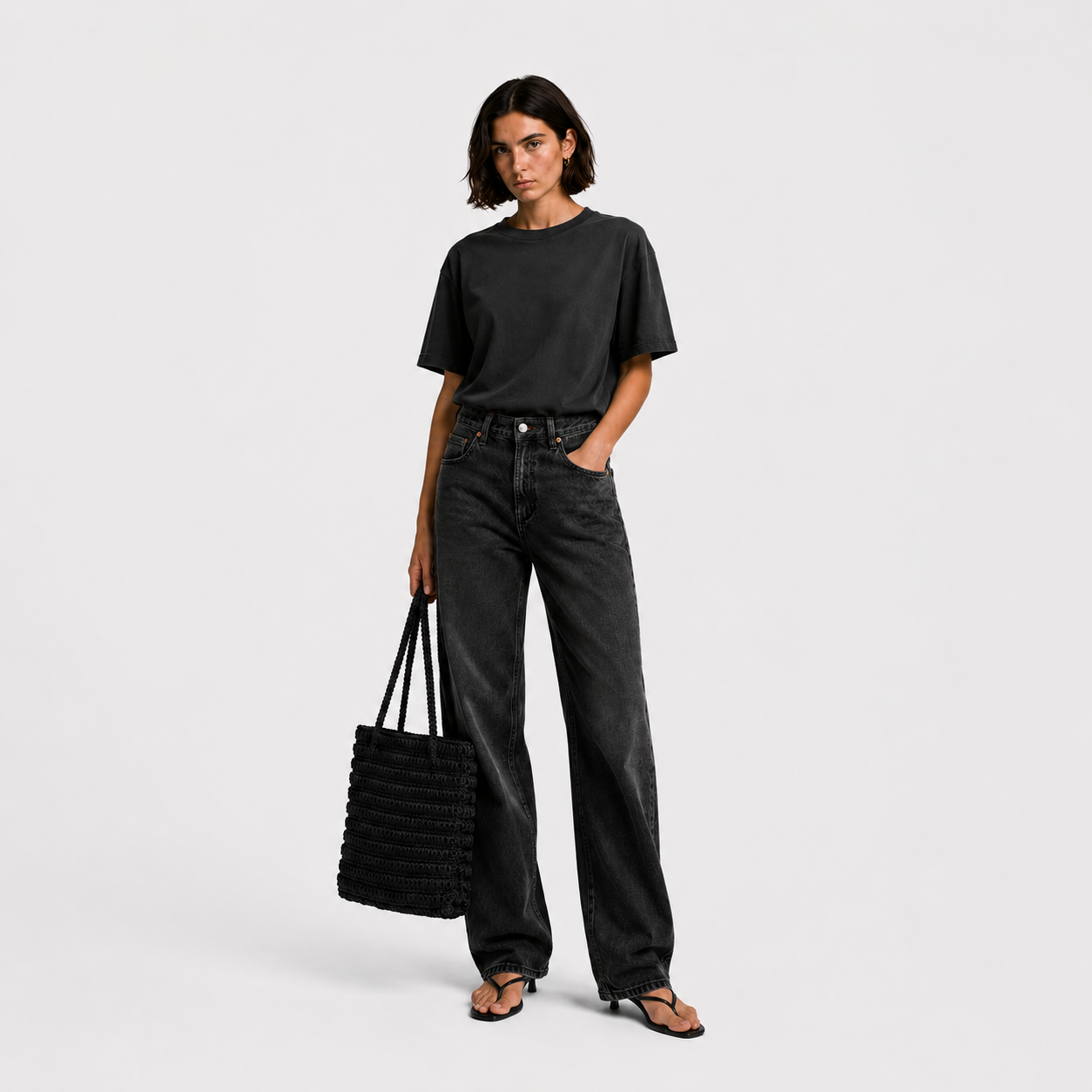 Model wearing THE STAPLE BAG in black as a daily shoulder tote, styled with dark tee and wide-leg jeans
